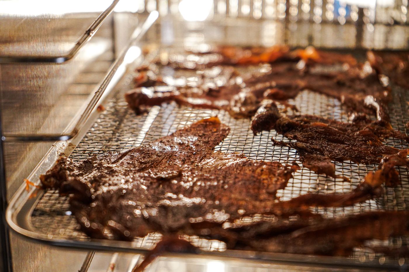 Marinated flank steak laid on drying racks